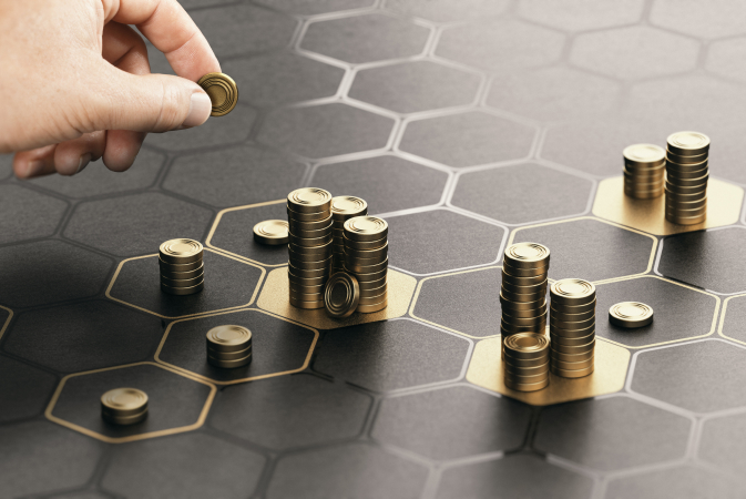 Close-up of a hand stacking golden coins on a hexagonal grid, symbolizing investment growth and financial strategy